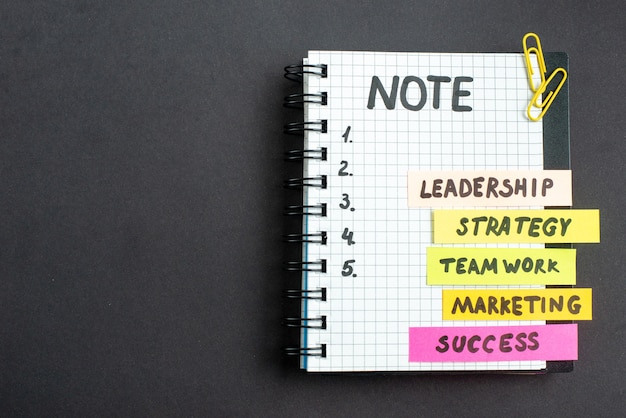 Gratis foto bovenaanzicht motivatie zakelijke notities met blocnote op donkere achtergrond zakelijk werk succes baan leiderschap strategie teamwerk marketing