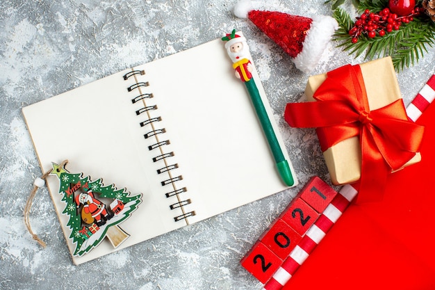 Bovenaanzicht notebook houtblokken kleine kerstmuts aanwezig groene kerstpen op grijs witte tafel