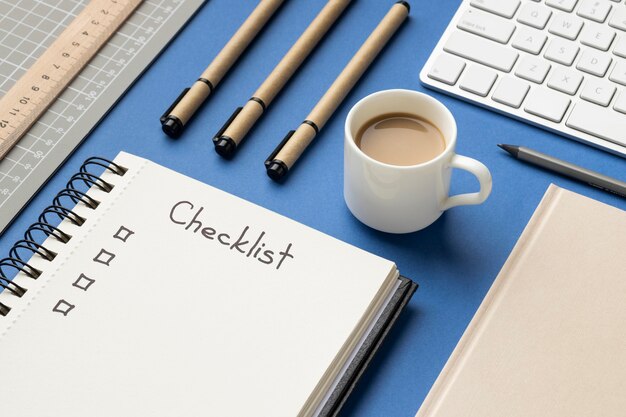 Bovenaanzicht notebook met checklist op bureau