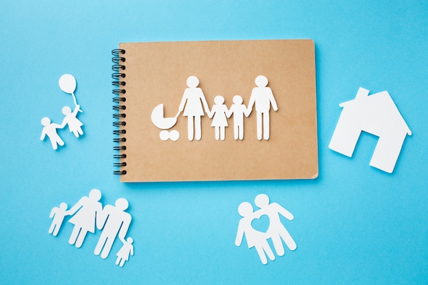 Gratis foto bovenaanzicht notebook met papier gesneden familie concept