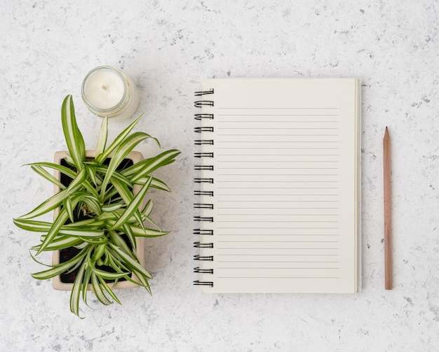 Bovenaanzicht notitieblok met planten en kaars