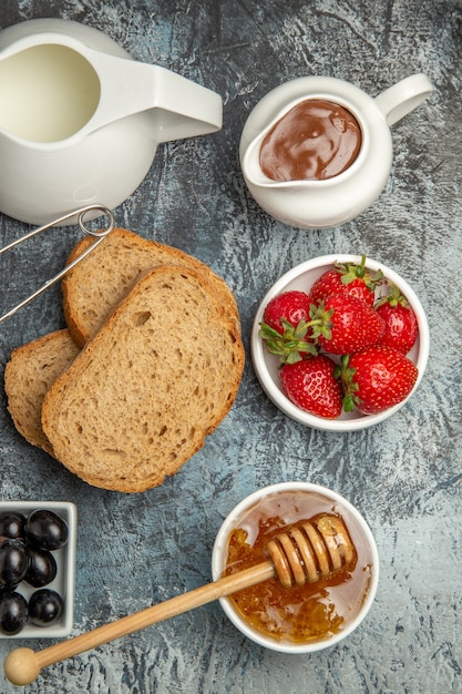 Bovenaanzicht ontbijt bureau brood honing en thee op een donkere vloer thee eten ochtend