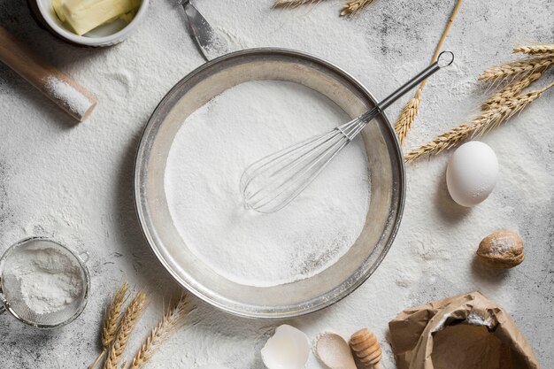 Bovenaanzicht pan gevuld met bakmeel op de tafel