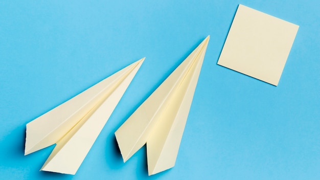 Bovenaanzicht papieren vliegtuigen met plaknotities op het bureau