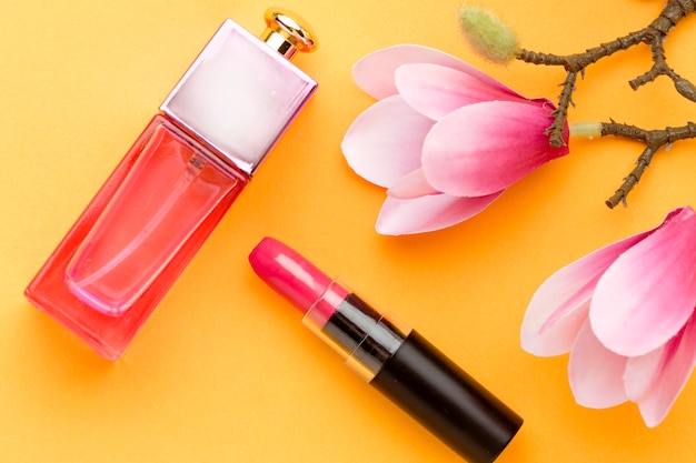 Gratis foto bovenaanzicht parfum met lippenstift en bloemen