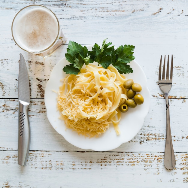 Gratis foto bovenaanzicht pastaschotel met een glas bier