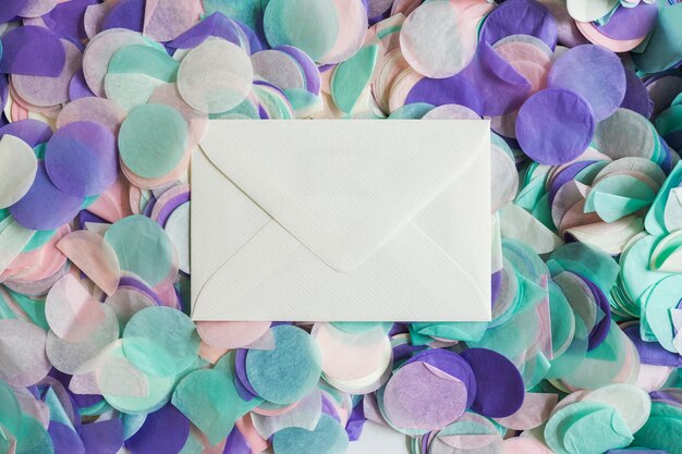 Bovenaanzicht pastel kleuren confetti met envelop in het midden