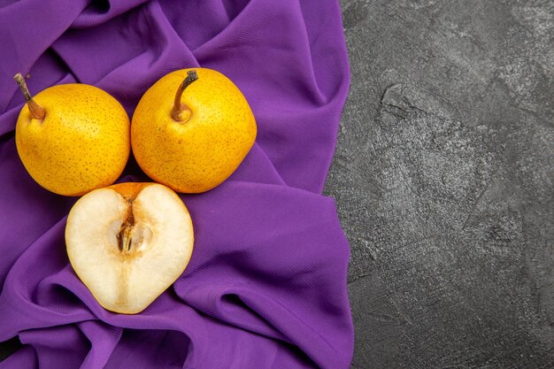 Bovenaanzicht peren en een halve peer een halve peer en een halve peer op het tafelkleed aan de linkerkant van de tafel