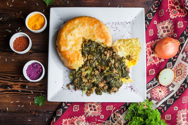 Bovenaanzicht pilaf in een pitabroodje met met kruiden, uien en kruiden. traditionele oosterse schotel op een donker houten oppervlak horizontaal