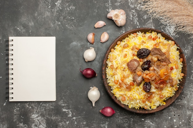 Bovenaanzicht pilaf knoflook ui een smakelijke pilaf in de houten kom notebook