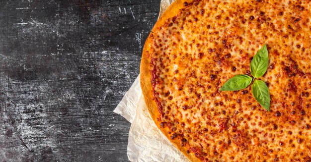 Bovenaanzicht pizza met kaas en basilicum met kopie-ruimte