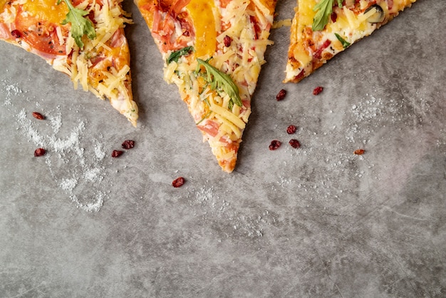 Gratis foto bovenaanzicht pizza plakjes met cement achtergrond