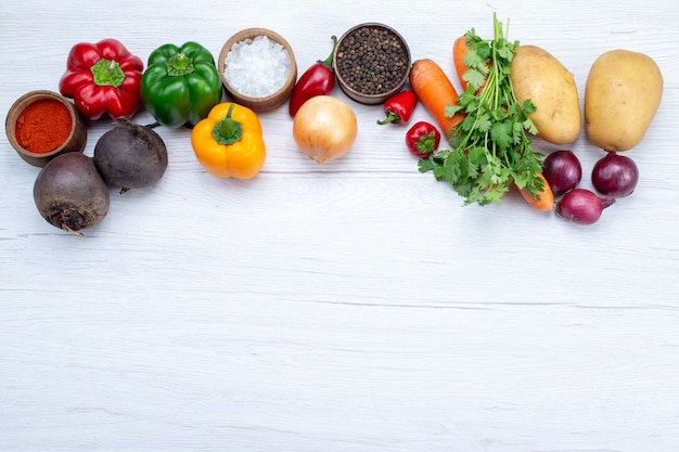 Bovenaanzicht plantaardige samenstelling met verse groenten greens rauwe bonen wortelen en aardappelen op de lichte achtergrond maaltijd groente salade