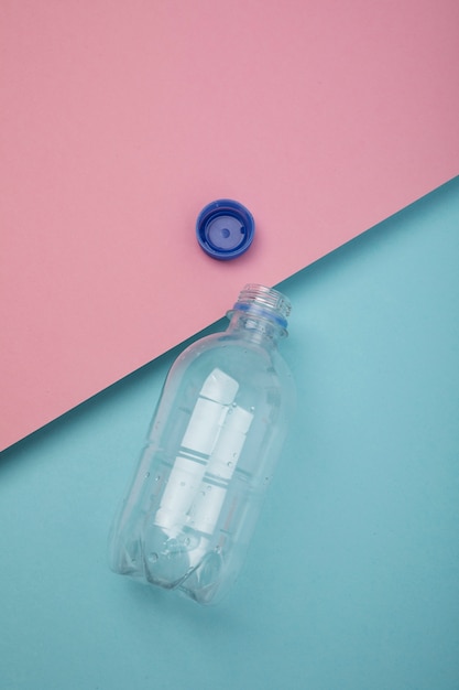 Bovenaanzicht plastic fles op roze en blauwe achtergrond