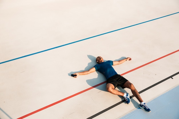 Bovenaanzicht portret van een uitgeputte jonge Afrikaanse fitness man