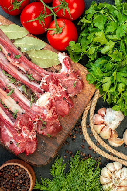 Gratis foto bovenaanzicht rauw vlees plakjes met greens op donkere achtergrond bak slager eten schotel maaltijd salade vlees koken