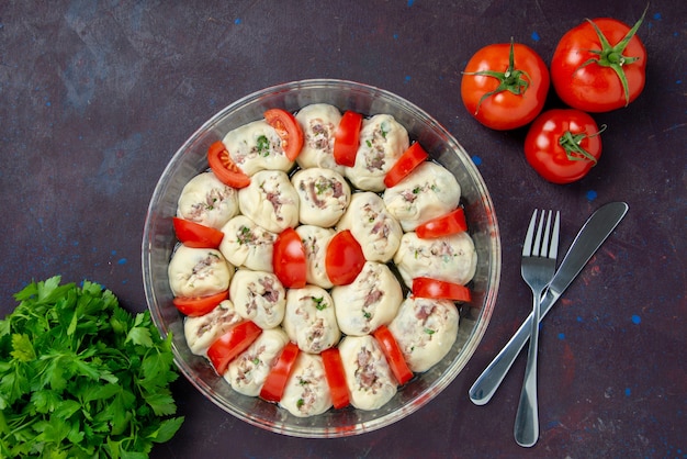 Bovenaanzicht rauwe deegstukken met gehakt en verse rode tomaten op een donkere maaltijd keuken kleur voedsel foto gerecht keuken