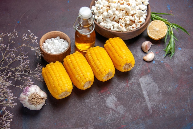 Bovenaanzicht rauwe gele likdoorns met verse popcorn op donkere oppervlakte snack popcorn film plant maïs