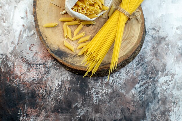 Bovenaanzicht rauwe gele pasta op lichte ondergrond