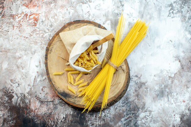 Bovenaanzicht rauwe gele pasta op lichte ondergrond