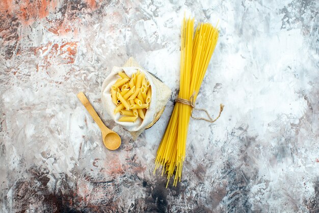 Bovenaanzicht rauwe gele pasta op lichte ondergrond