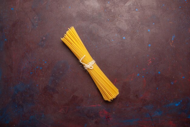 Bovenaanzicht rauwe Italiaanse pasta lang gevormd op een donkere achtergrond maaltijd eten deeg pasta rauw