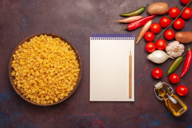 Bovenaanzicht rauwe Italiaanse pasta met verse groenten op donkere achtergrond plantaardige pasta maaltijd eten