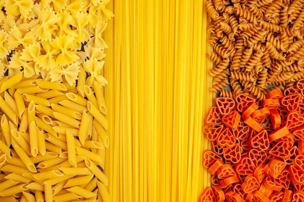 Bovenaanzicht rauwe Italiaanse pasta verschillend gevormd op lichtgrijze achtergrond