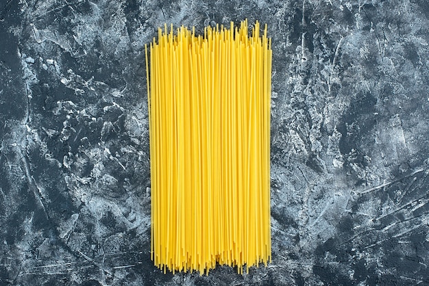 Bovenaanzicht rauwe lange pasta op de grijze achtergrond keuken pasta deeg keuken keuken kleur voedsel koken