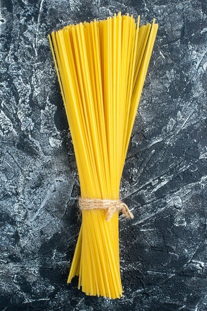 Bovenaanzicht rauwe lange pasta op grijze achtergrond keuken pasta deeg keuken kleur voedsel koken keuken