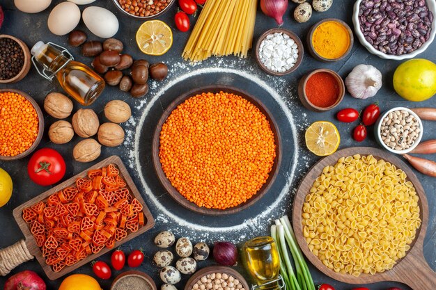 Bovenaanzicht rauwe linzen met noten eieren pasta en kruiderijen op donkere achtergrond fruit walnoot maaltijd foto taart voedsel gebak kleur zoet