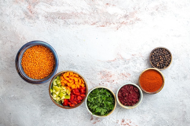 Bovenaanzicht rauwe oranje bonen met kruiden op licht wit oppervlak maaltijd boon merci plantaardig ingrediënt