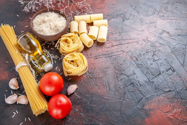 Bovenaanzicht rauwe pasta met rijst op donkere oppervlak deeg pasta rauw