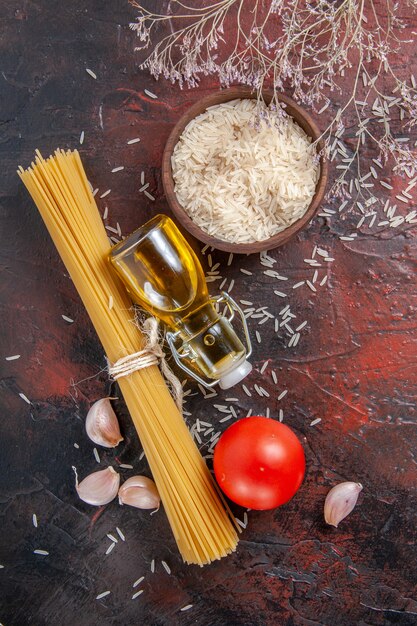 Bovenaanzicht rauwe pasta met verschillende ingrediënten op donkere kleur pastadeeg