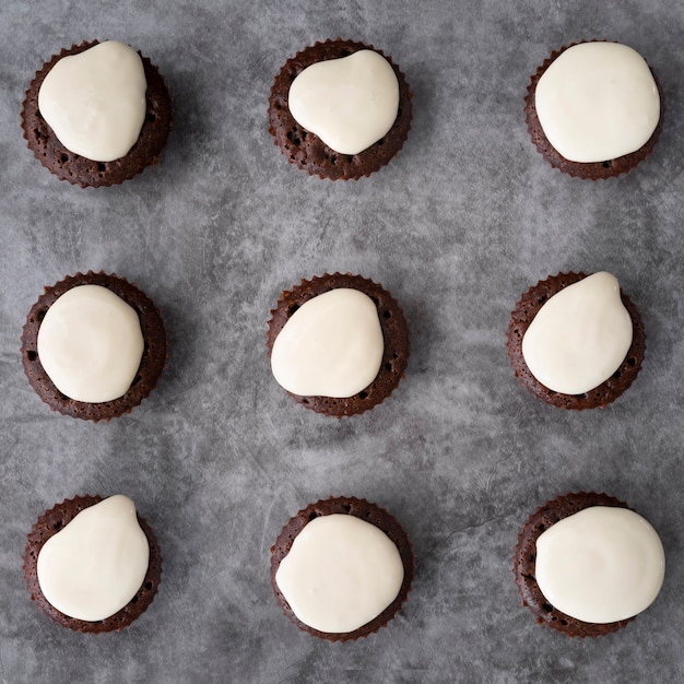 Bovenaanzicht regeling met smakelijke cupcakes op stucwerk achtergrond