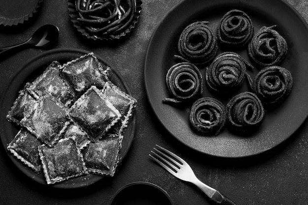 Bovenaanzicht regeling van zwart heerlijk eten op donkere plaat en tafel