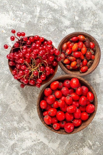 Gratis foto bovenaanzicht rode bessen zacht fruit op lichtwitte achtergrond