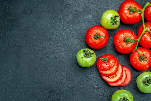 Bovenaanzicht rode tomatentak groene tomaten op donkere achtergrond