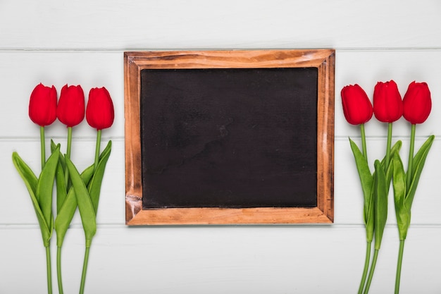 Gratis foto bovenaanzicht rode tulpen naast frame