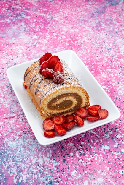 Bovenaanzicht roll cake met rode aardbeien in witte plaat op de gekleurde achtergrond cake biscuit zoete kleur