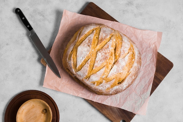 Bovenaanzicht ronde brood met mes op bakpapier