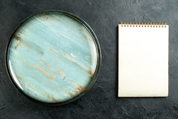 Bovenaanzicht ronde schotel notebook op zwarte tafel stock foto