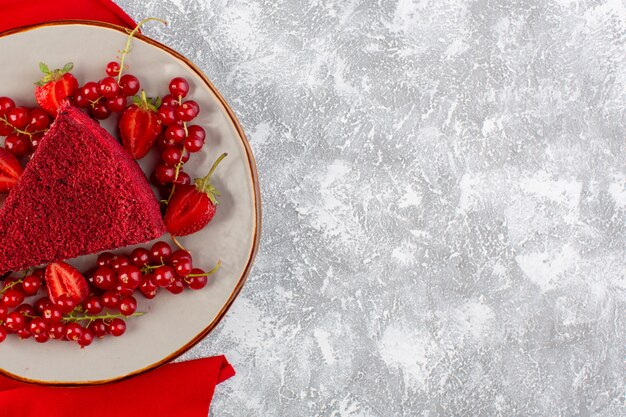 Bovenaanzicht rood cake stuk fruitcake stuk binnen plaat met verse veenbessen en aardbeien op de grijze achtergrond cake zoete koekjessuiker