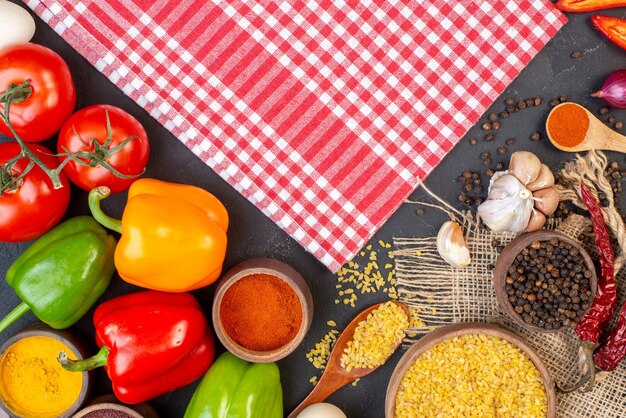 Bovenaanzicht rood tafelkleed gekleurde paprika bulgur in kom uien op tafel