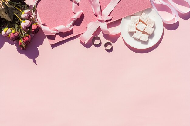 Bovenaanzicht roze bruiloft arrangement met roze achtergrond