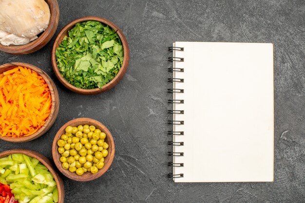 Bovenaanzicht salade ingrediënten met kip en greens op de donkere tafel gezondheidssalade dieetvoeding