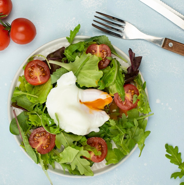 Bovenaanzicht salade met gebakken ei en tomaten