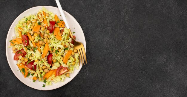 Bovenaanzicht salade met kikkererwten en wortelen met kopie-ruimte