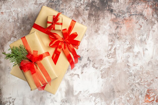 Bovenaanzicht schattige kerstcadeautjes vastgebonden met rode strikken op lichte achtergrond