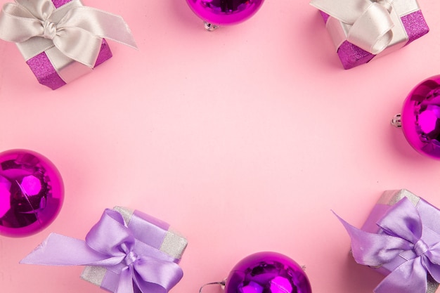Bovenaanzicht schattige kleine cadeautjes met kerstboom speelgoed op de roze achtergrond